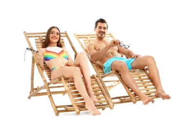 Photo of Young couple on sun loungers against white background. Beach accessories