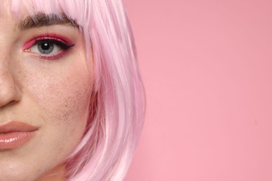 Photo of Beautiful woman with bright makeup and fake freckles on pink background, closeup. Space for text