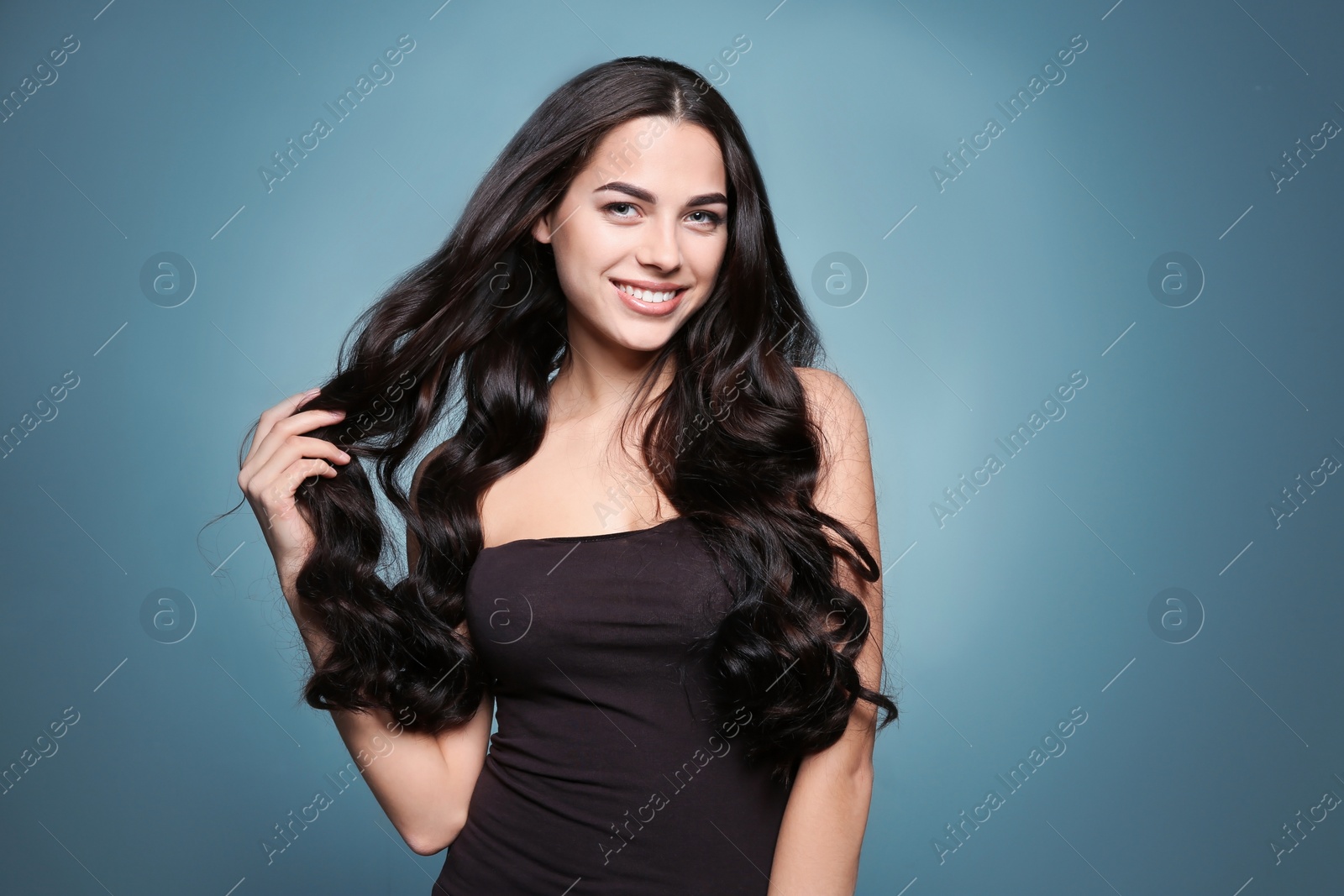 Photo of Portrait of beautiful model with gorgeous curly hair on color background