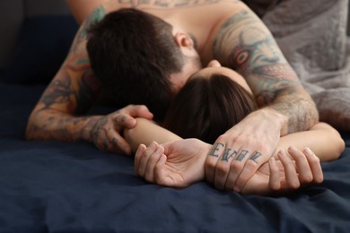 Photo of Passionate couple having sex on bed, focus on hands