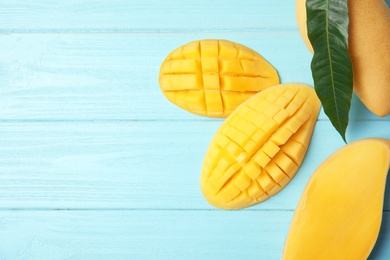 Flat lay composition with mango on wooden background. Space for text