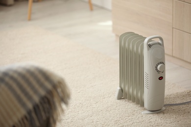 Photo of Modern electric heater on floor at home