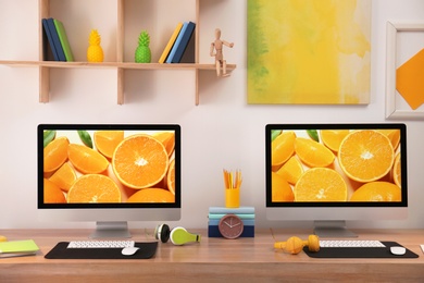 Photo of Modern workplace with large desk and computers in room. Stylish interior