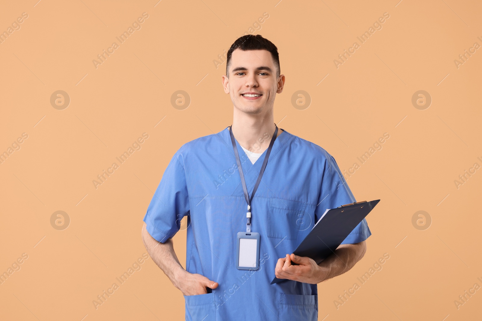 Photo of Portrait of smiling medical assistant with clipboard on beige background