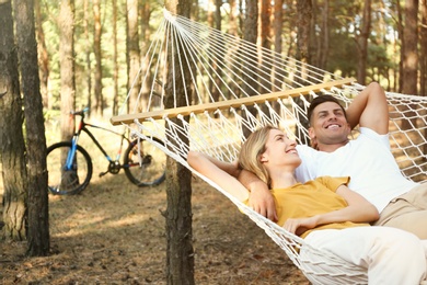 Happy couple resting in hammock outdoors on summer day