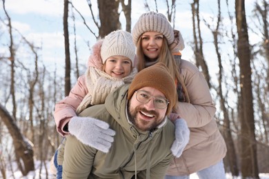 Photo of Happy family spending time together in snowy forest
