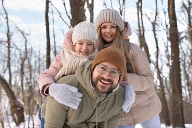 Happy family spending time together in snowy forest