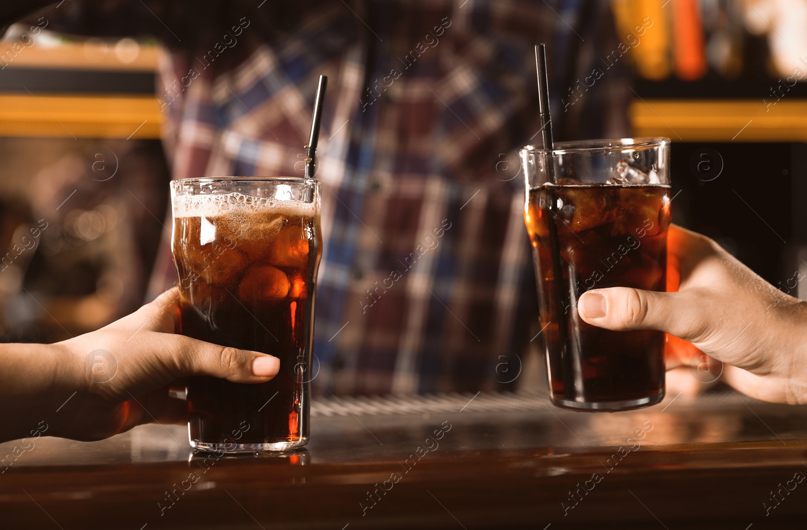 Photo of Couple with glasses of refreshing cola at bar counter, closeup