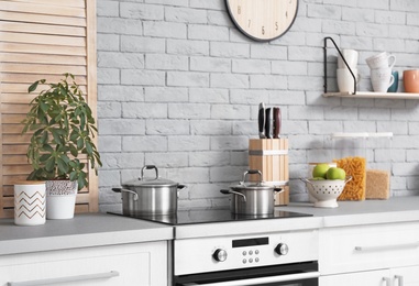 Photo of Modern kitchen interior with new furniture and different utensils