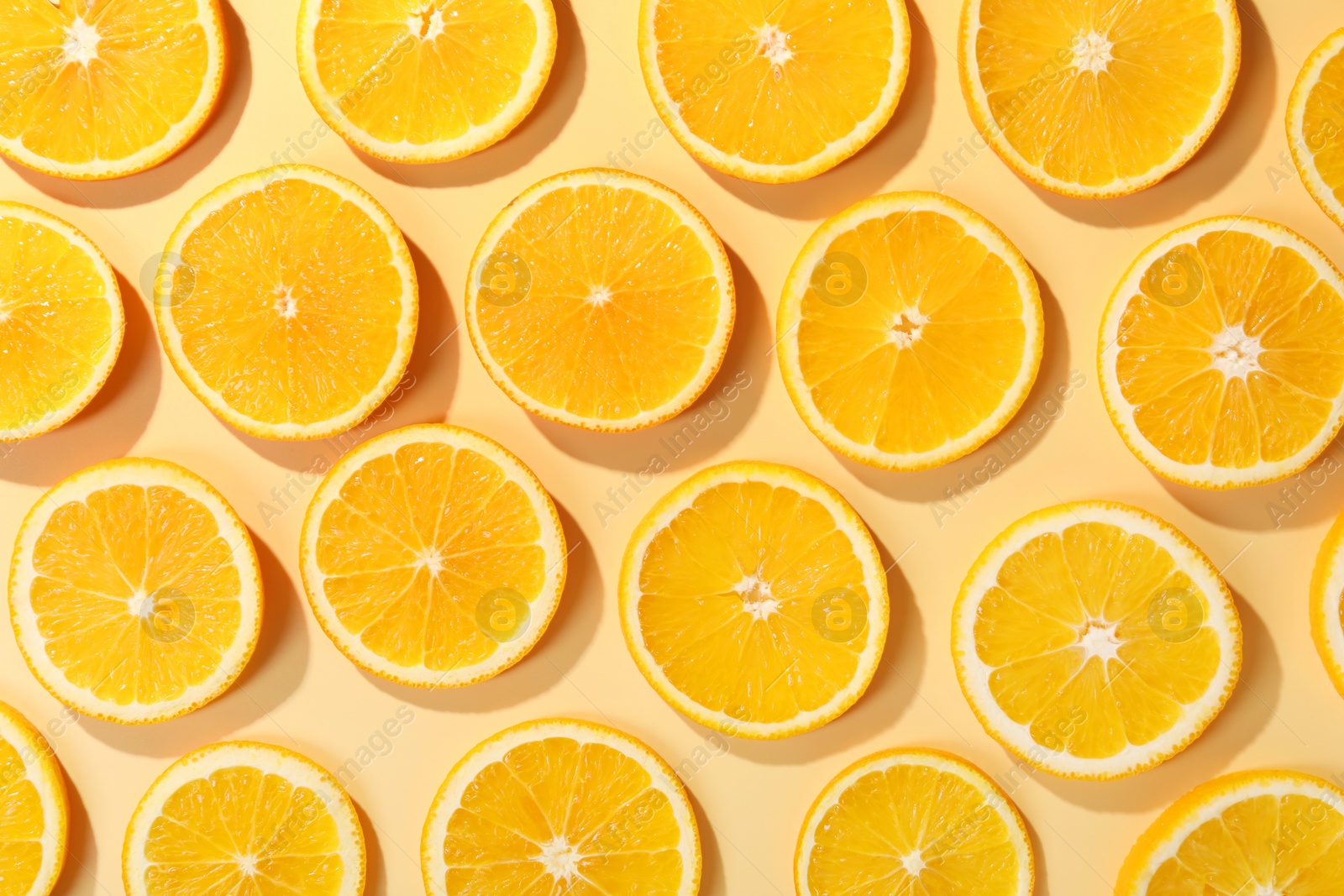 Photo of Slices of juicy orange on beige background, flat lay