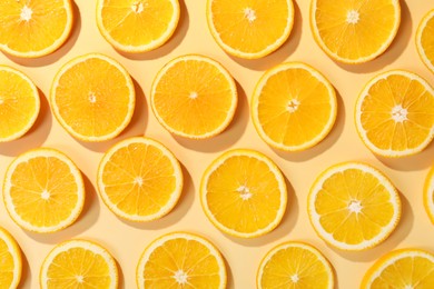 Photo of Slices of juicy orange on beige background, flat lay