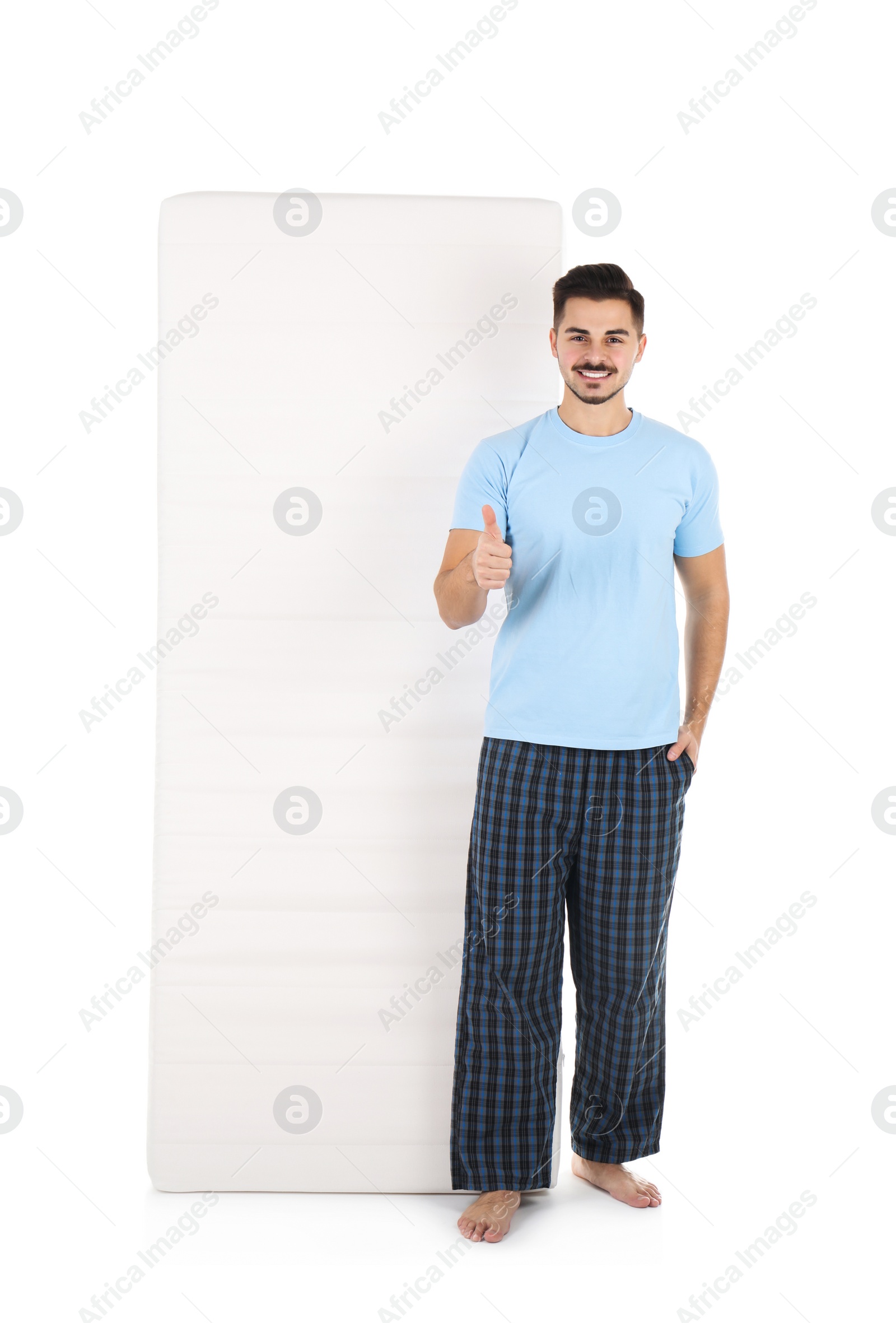 Photo of Young man with comfortable mattress isolated on white