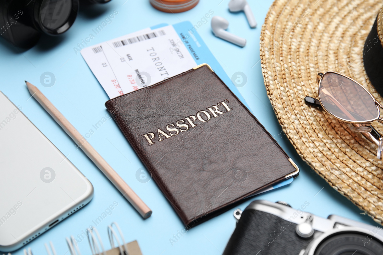 Photo of Passport with tickets near travel items on light blue background