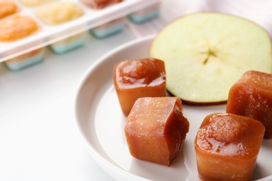 Photo of Frozen apple puree cubes with ingredient on table, closeup