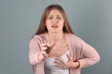 Photo of Young woman having heart attack on color background