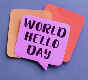 Image of Paper note with phrase World Hello Day on color background, top view