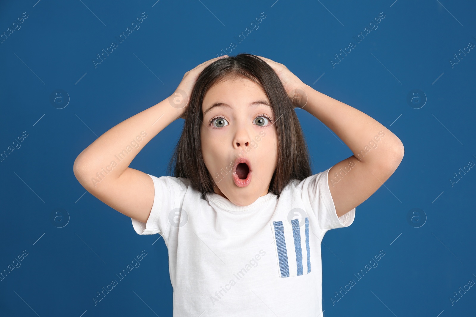 Photo of Portrait of cute little girl on blue background