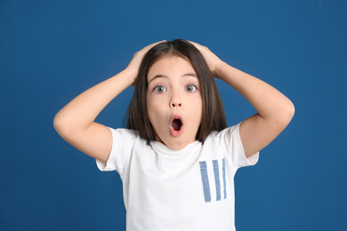 Photo of Portrait of cute little girl on blue background