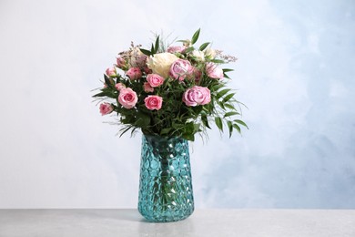 Beautiful bouquet with roses on light table