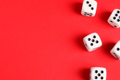 Photo of Many white game dices on red background, flat lay. Space for text