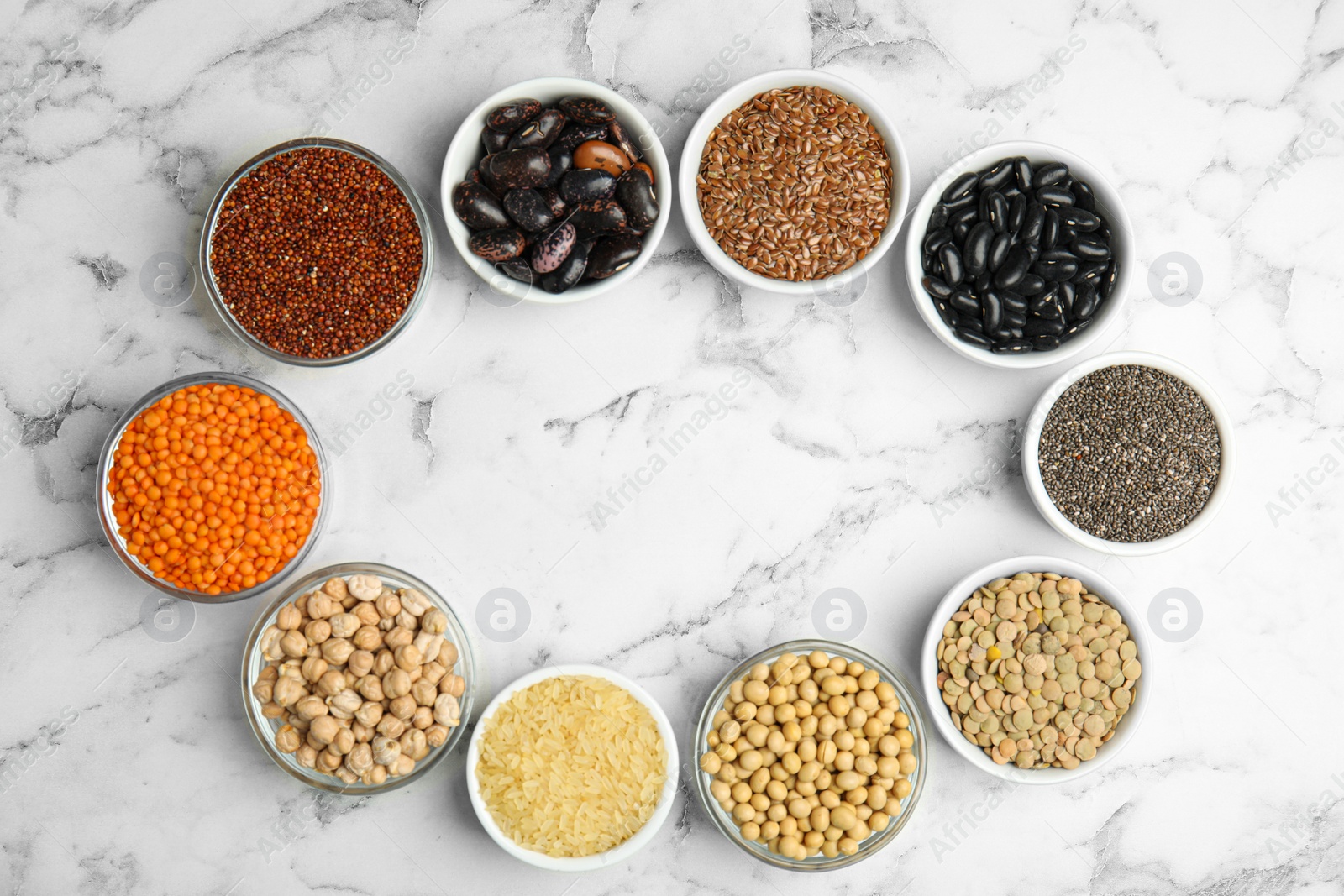 Photo of Frame of different grains and seeds with space for text on white marble table, flat lay. Veggie diet