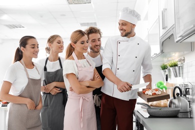 Photo of Group of people and male chef at cooking classes