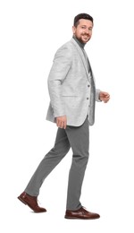 Photo of Handsome bearded businessman walking on white background