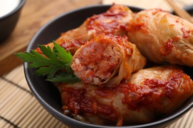 Photo of Delicious stuffed cabbage rolls cooked with homemade tomato sauce on table, closeup