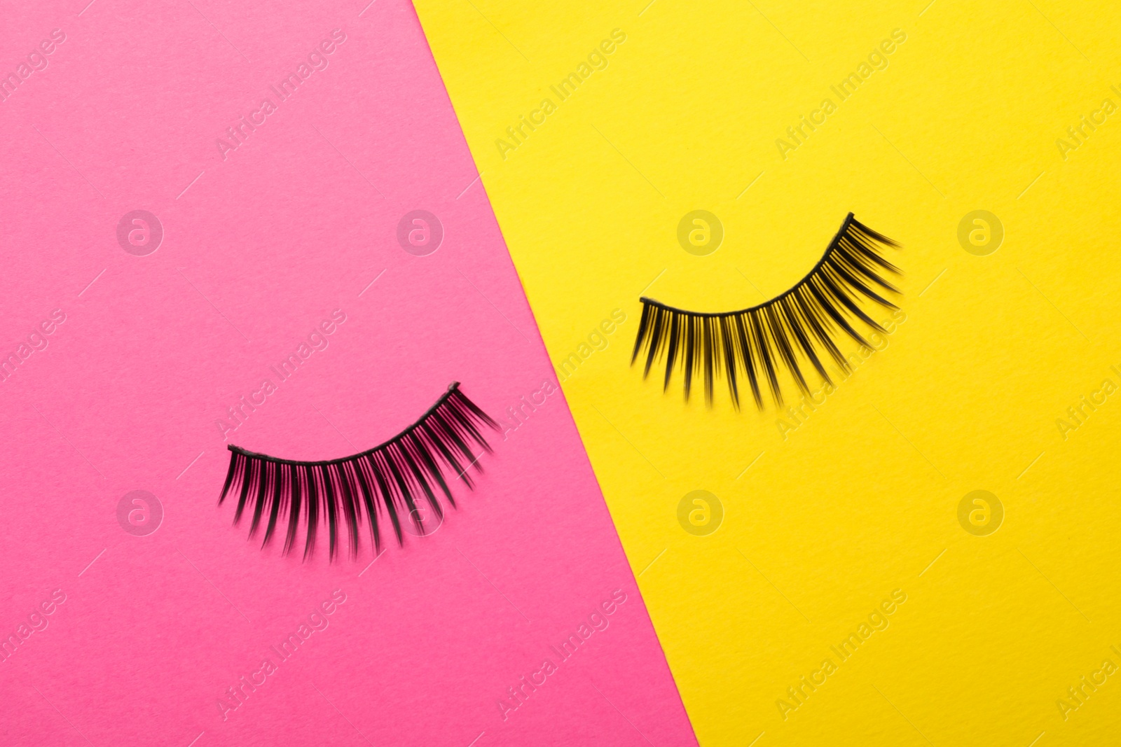 Photo of False eyelashes on color background, flat lay