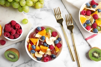 Photo of Fresh tasty fruit salad on white marble table, flat lay