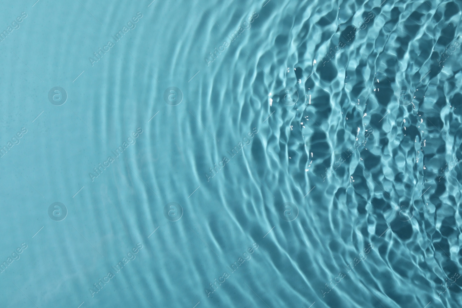 Photo of Closeup view of water with rippled surface on light blue background