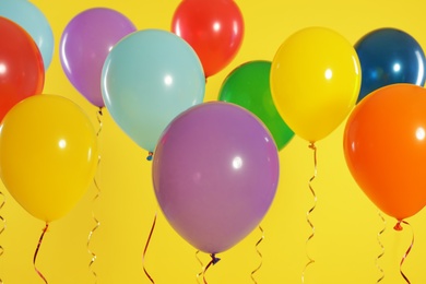 Photo of Bright balloons on color background. Celebration time