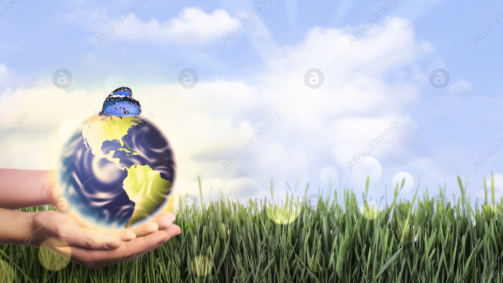 Image of Woman holding Earth with butterfly outdoors, closeup