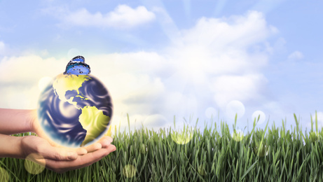 Image of Woman holding Earth with butterfly outdoors, closeup