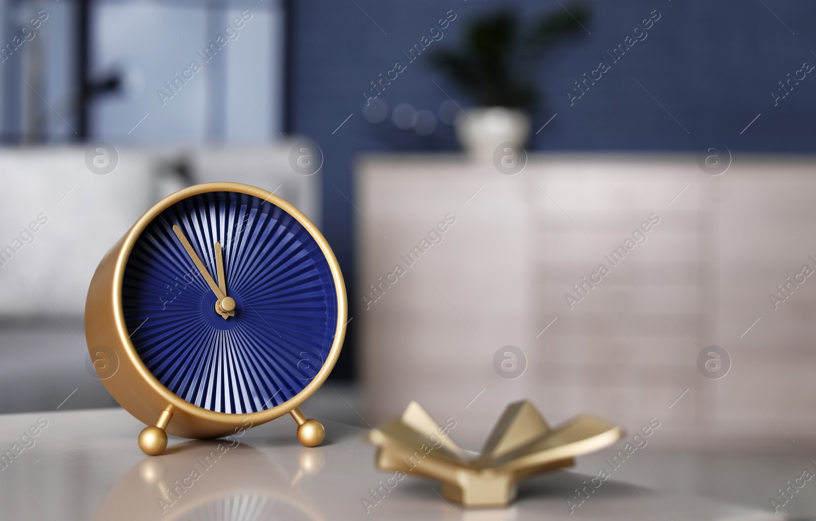 Photo of Analog alarm clock on table in living room. Time of day