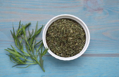 Dry and fresh tarragon on light blue wooden table, flat lay