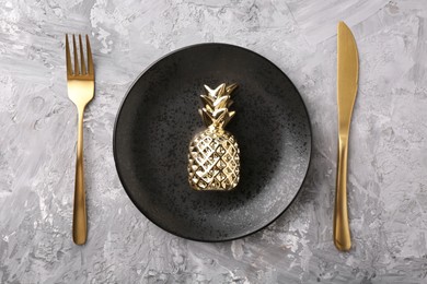 Elegant setting with golden cutlery on grey textured table, flat lay