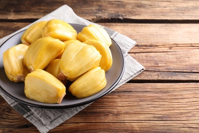 Photo of Delicious exotic jackfruit bulbs on wooden table