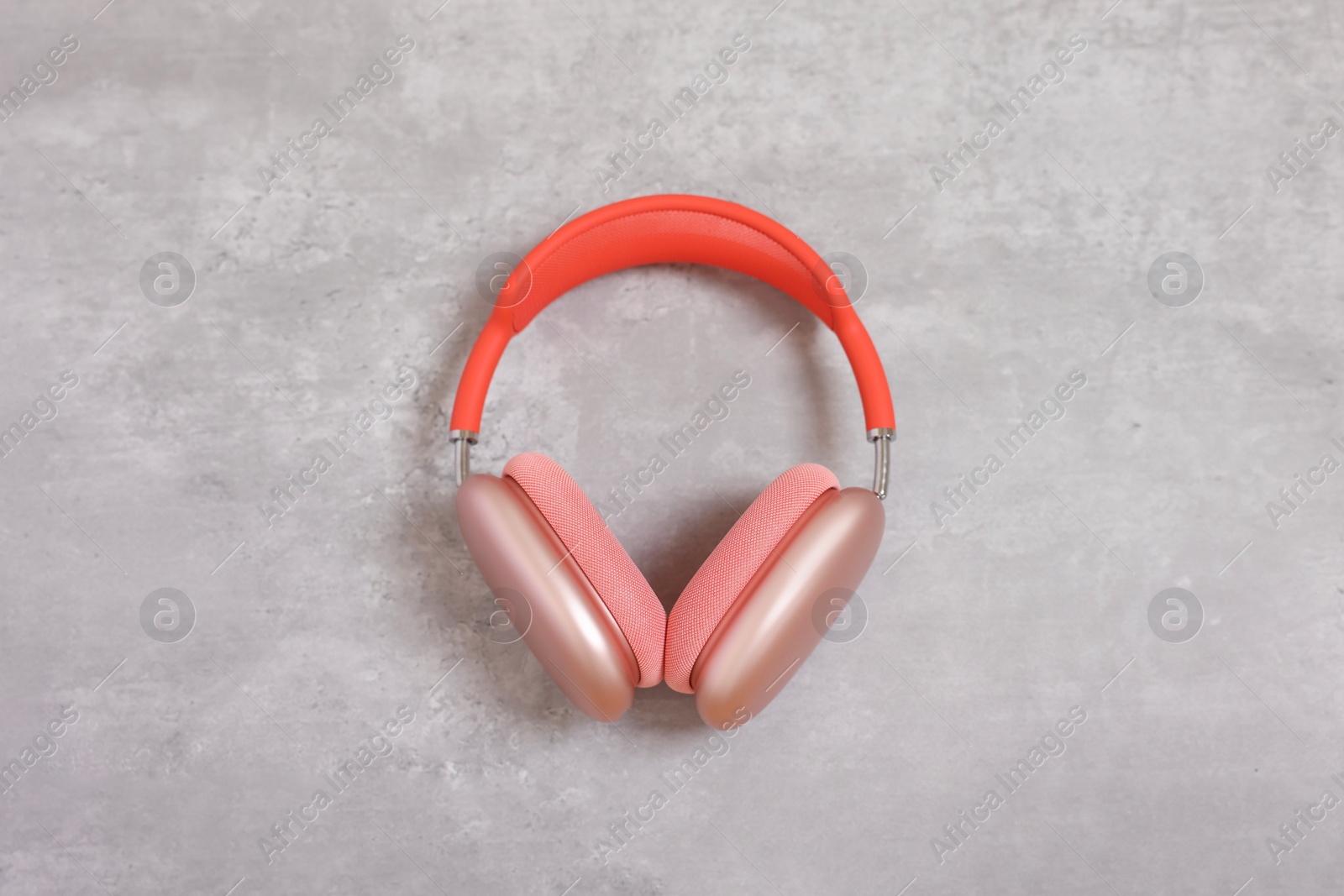 Photo of Stylish pink headphones on light grey table, top view