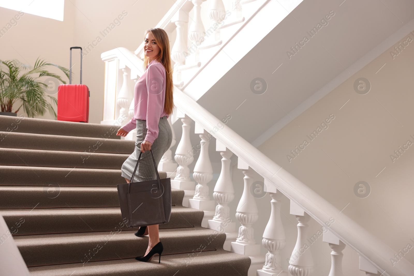 Photo of Beautiful businesswoman on stairs in modern hotel