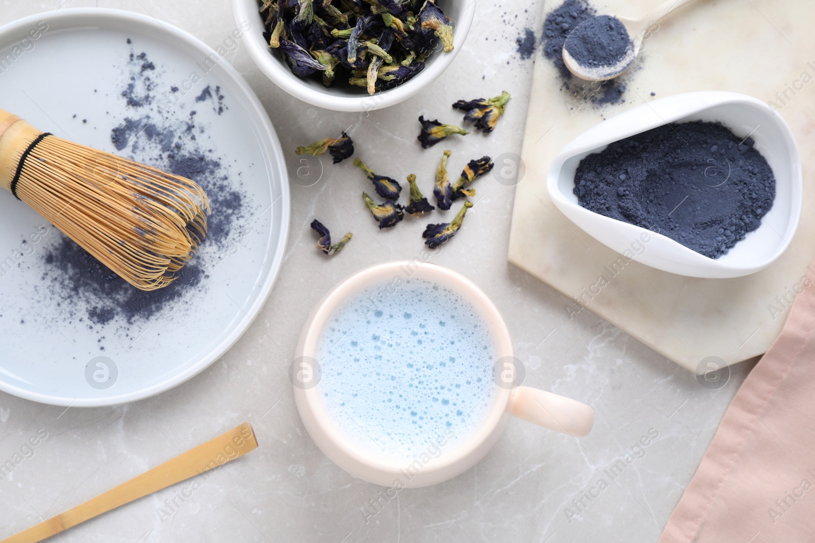 Image of Flat lay composition with blue matcha latte on light grey marble table