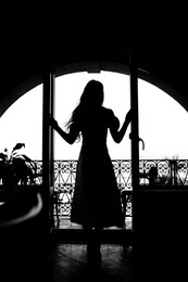 Silhouette of woman standing on balcony, back view