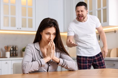 Stressed wife trying to ignore her angry husband in kitchen, selective focus. Relationship problems