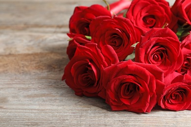 Photo of Beautiful red rose flowers on wooden background