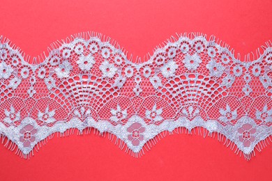 Light blue lace on red background, top view