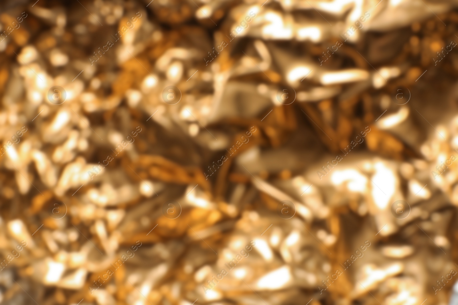 Photo of Blurred view of crumpled golden foil as background