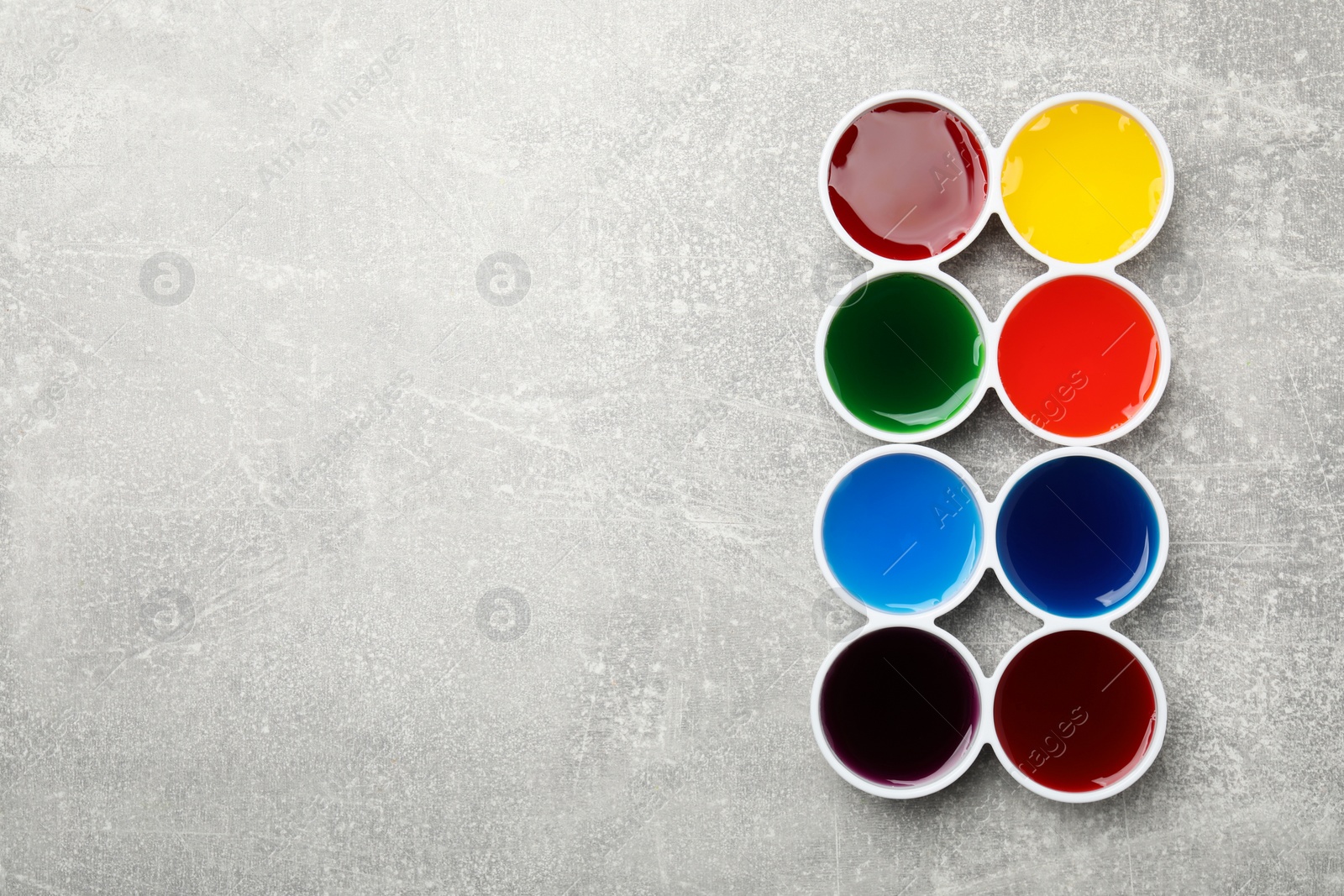 Photo of Bowls with many different food coloring on light grey table, flat lay. Space for text