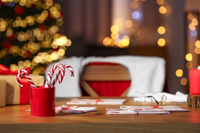 Santa's Claus workplace. Letters and candy canes on table in room with Christmas decor