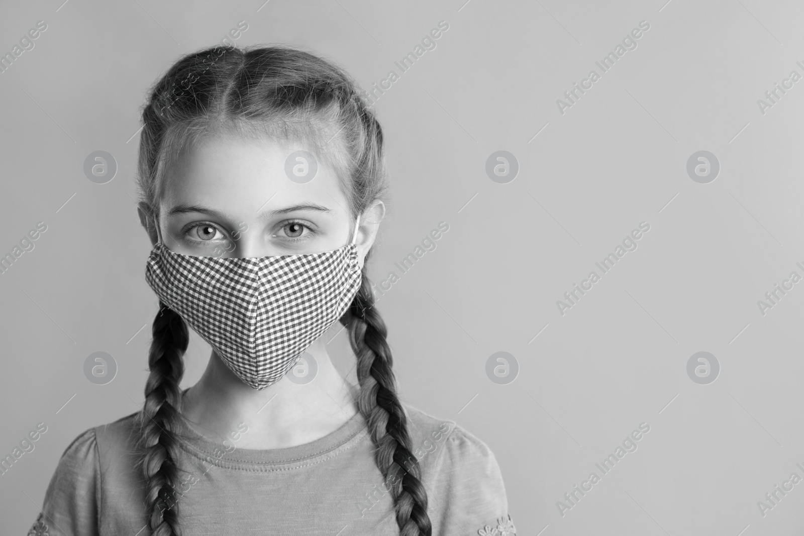 Image of Girl wearing medical face mask on light background, space for text. Black and white photography