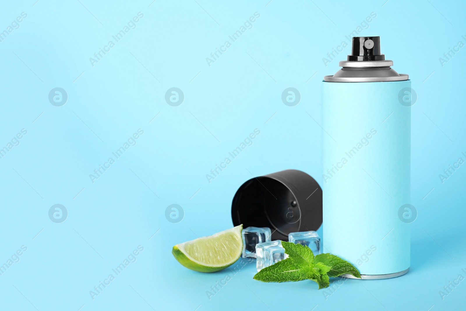 Photo of Spray deodorant, lime, mint and ice on light blue background, space for text